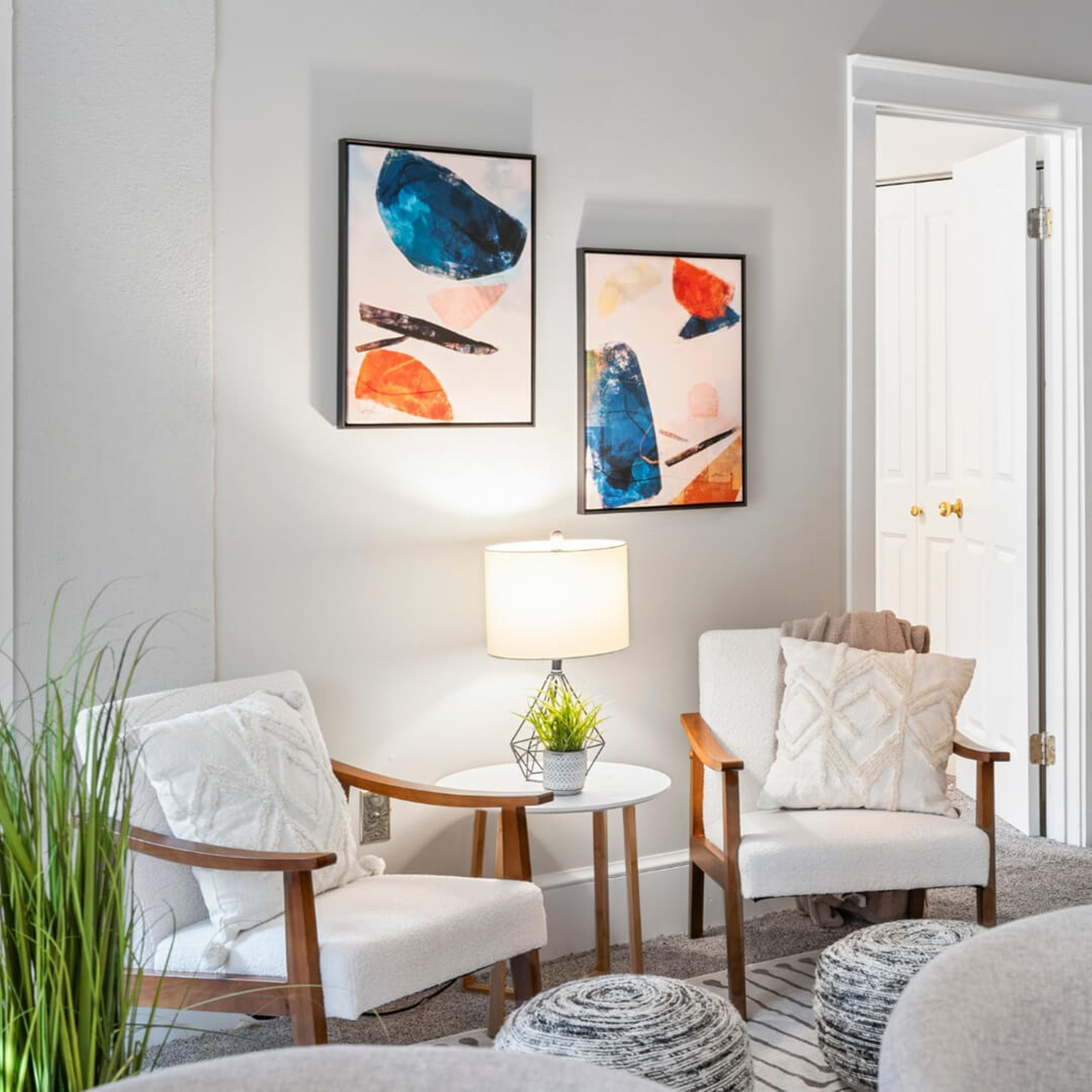 Luxurious living room with two arm chairs and a side table with a lamp between them.