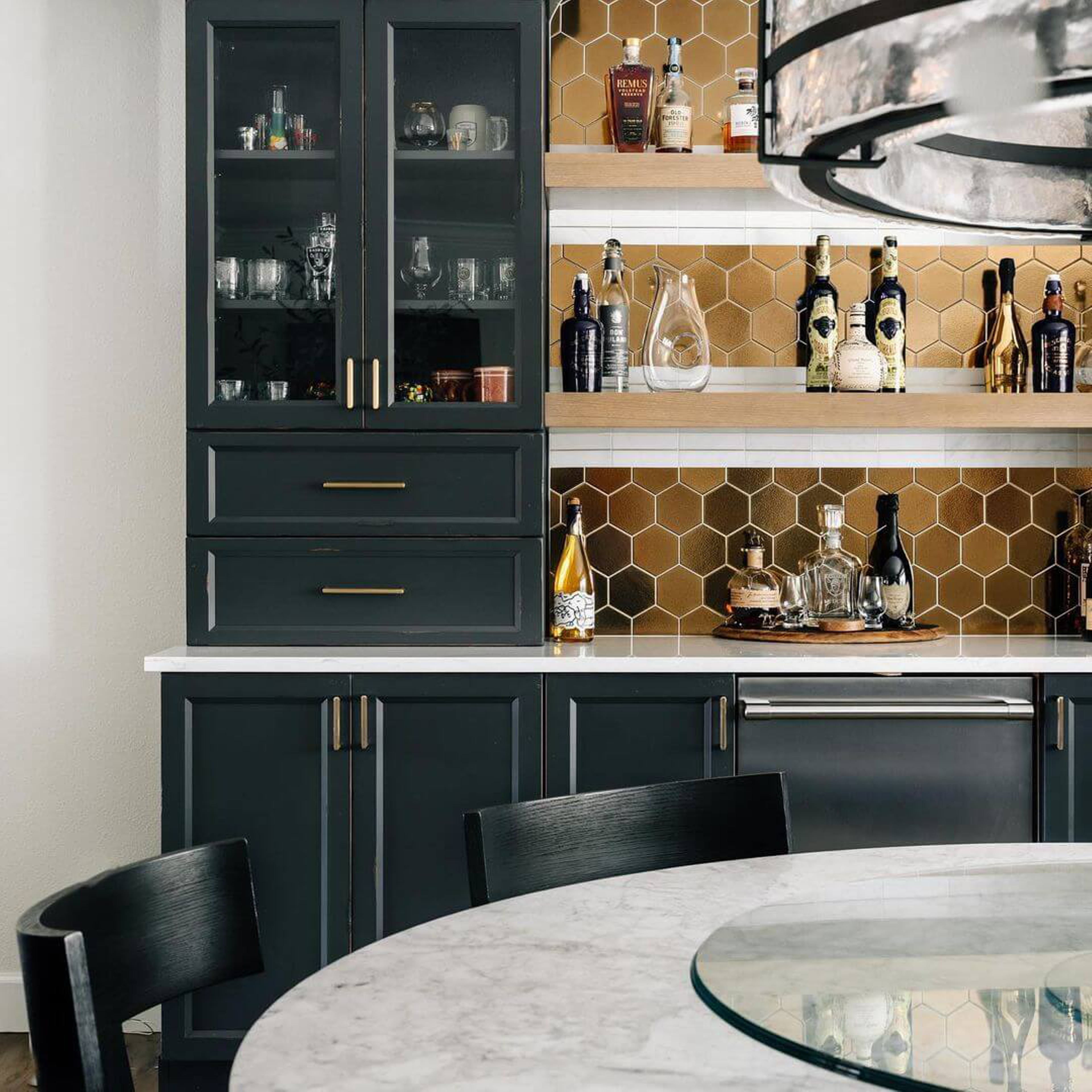 Dark navy blue kitchenette with hexagonal patters and gold accents.